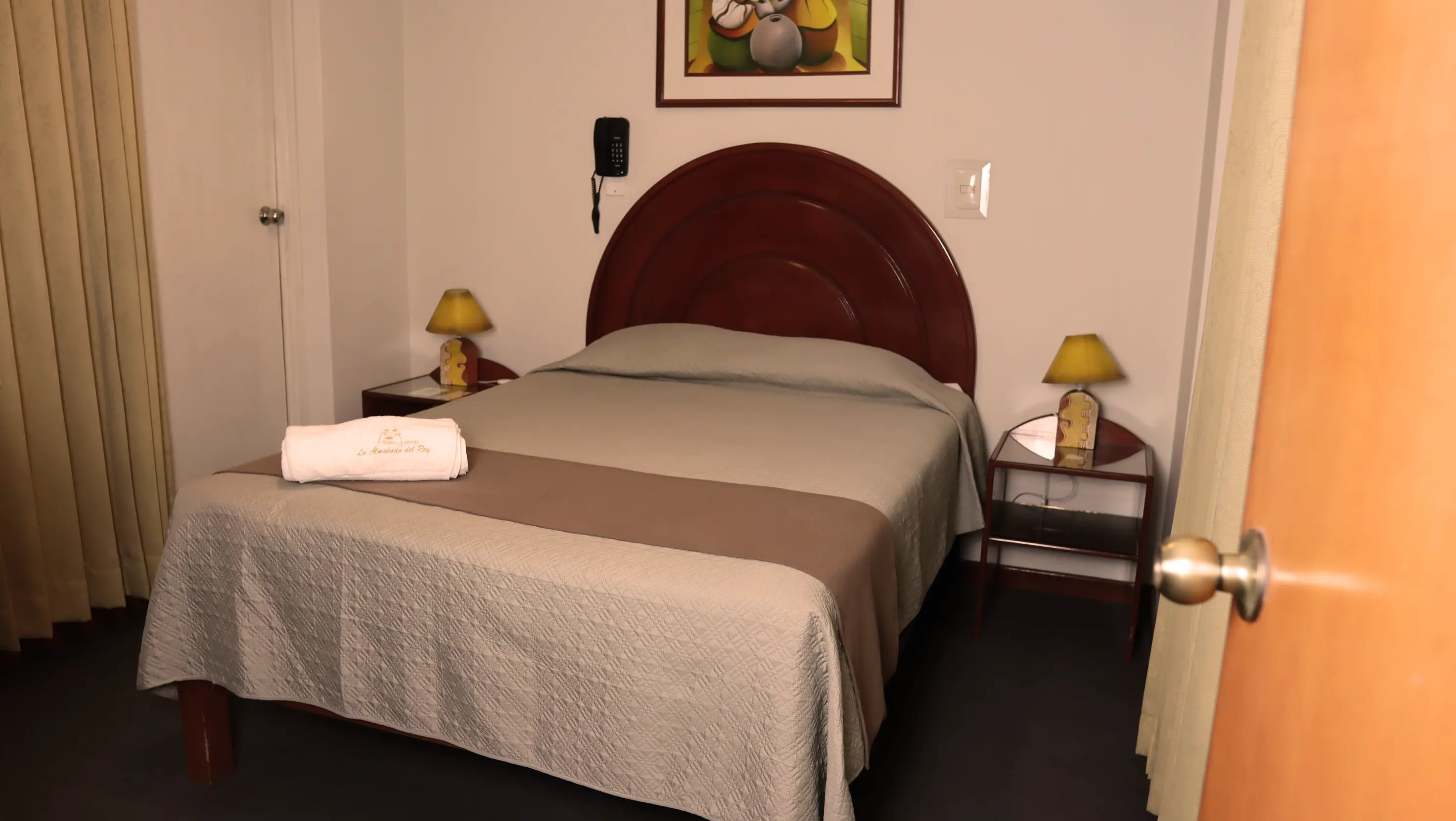 Habitación individual con colcha a cuadros y lámpara de noche