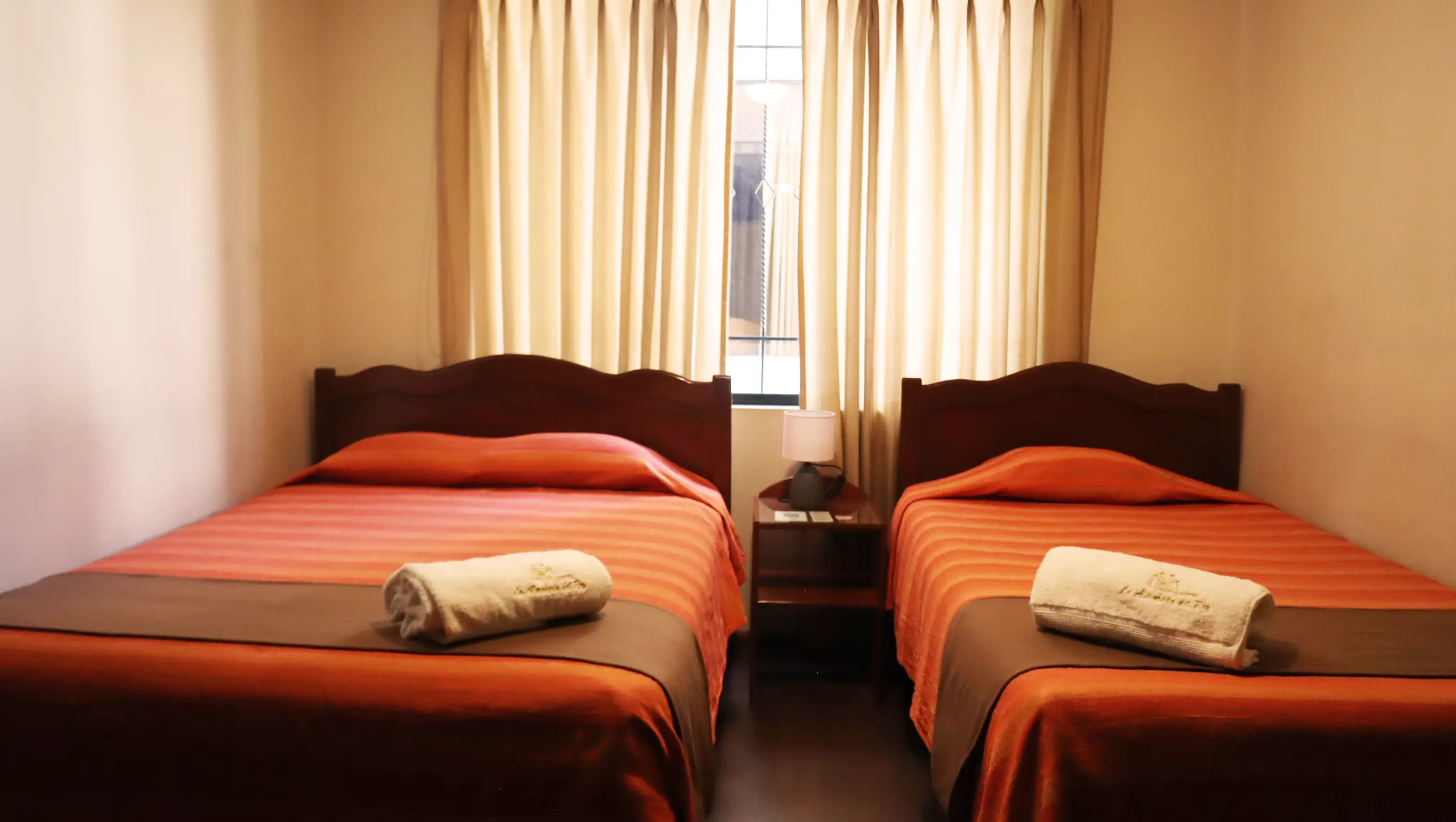 Habitación con dos camas individuales con colchas moradas